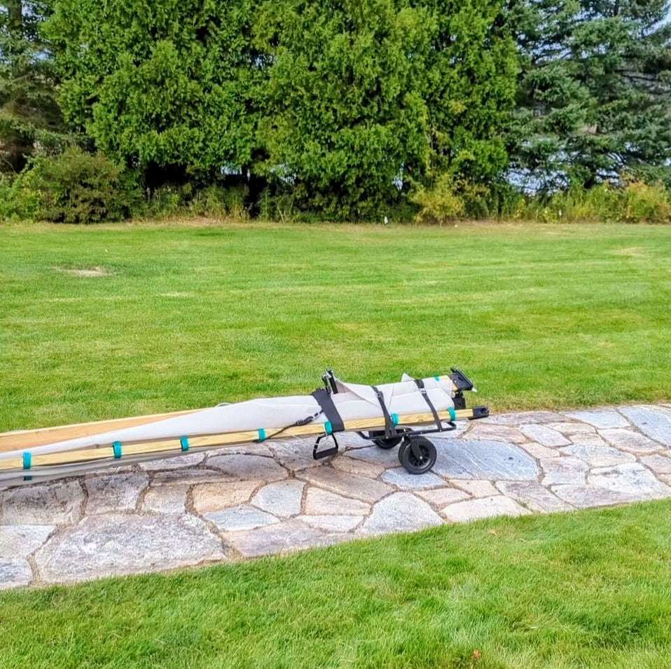 Lawn roller resting on paving stones with extended handle and wheels