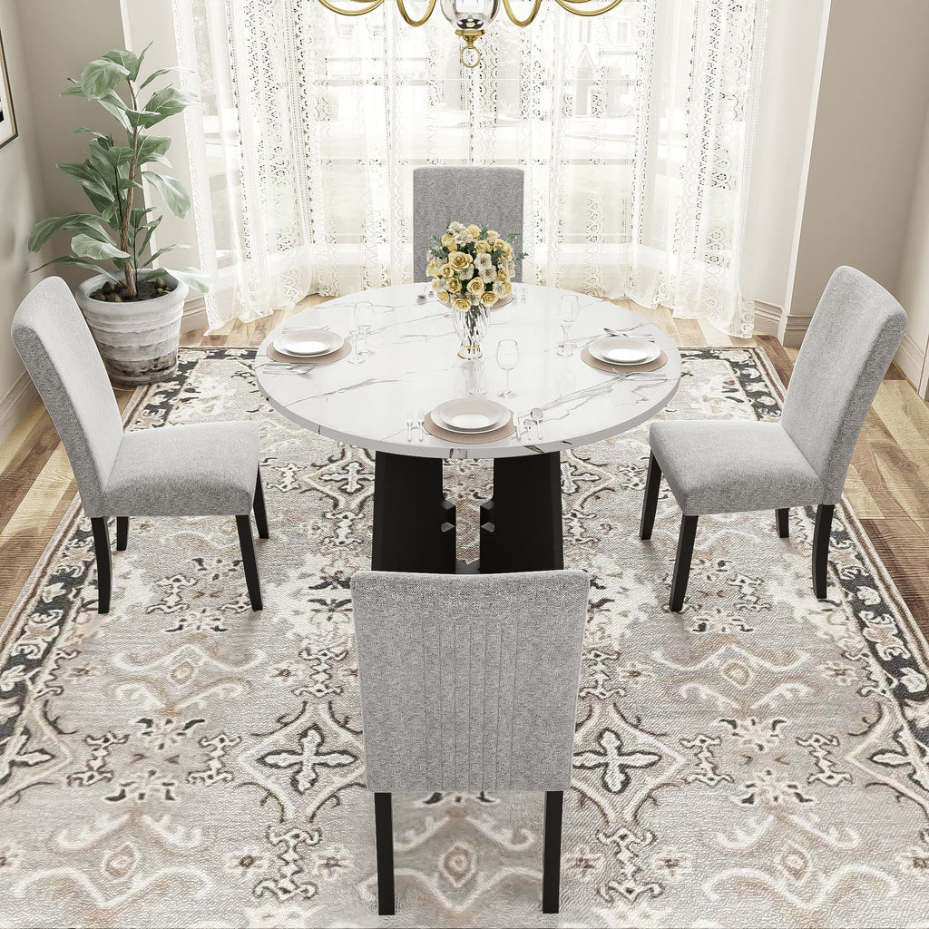 Round white marble-look dining table with four gray upholstered chairs around it