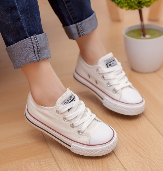 White low-top canvas sneakers with lace-up closure and rubber sole