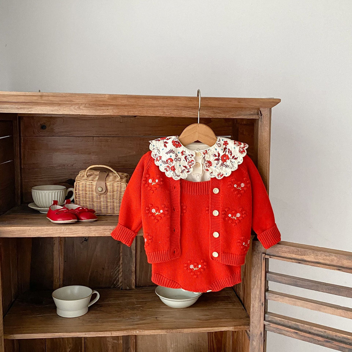 Red knit baby girl cardigan romper with embroidered hearts and cream scalloped collar