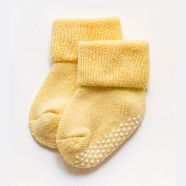 Yellow children's non-slip socks with grippy dot pattern on the sole