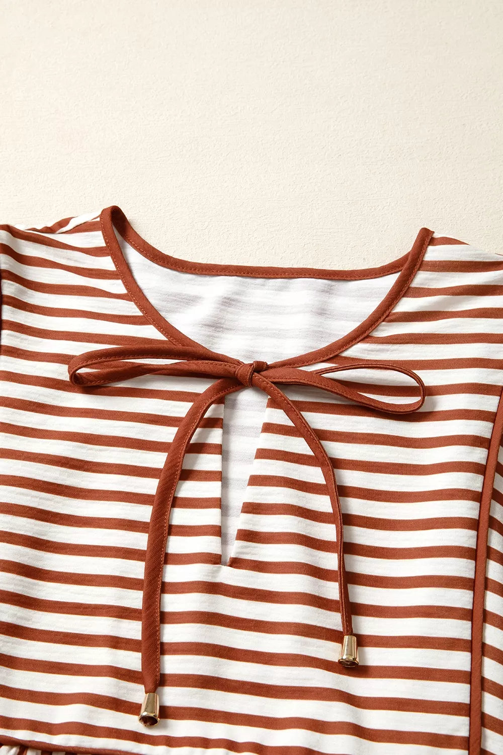 Striped babydoll blouse neckline with drawstring tie and brown-and-white stripes