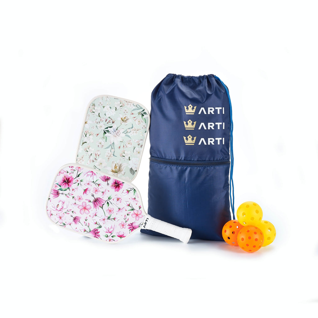 Pickleball starter set with floral paddle, navy drawstring bag, and orange pickleball balls