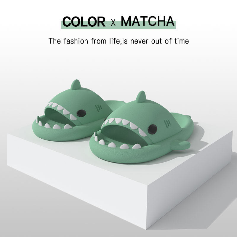 Green shark slide sandals on a white display box base, open toe design