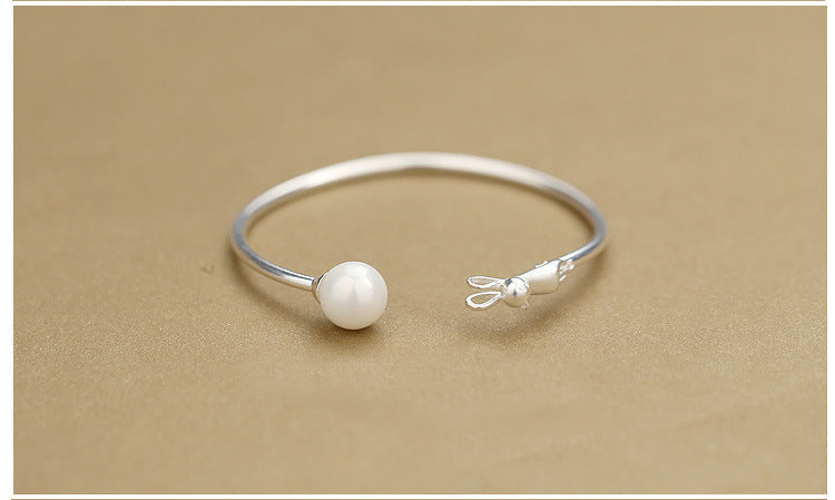 Silver cat charm bracelet with round pearl bead on a smooth slim bangle