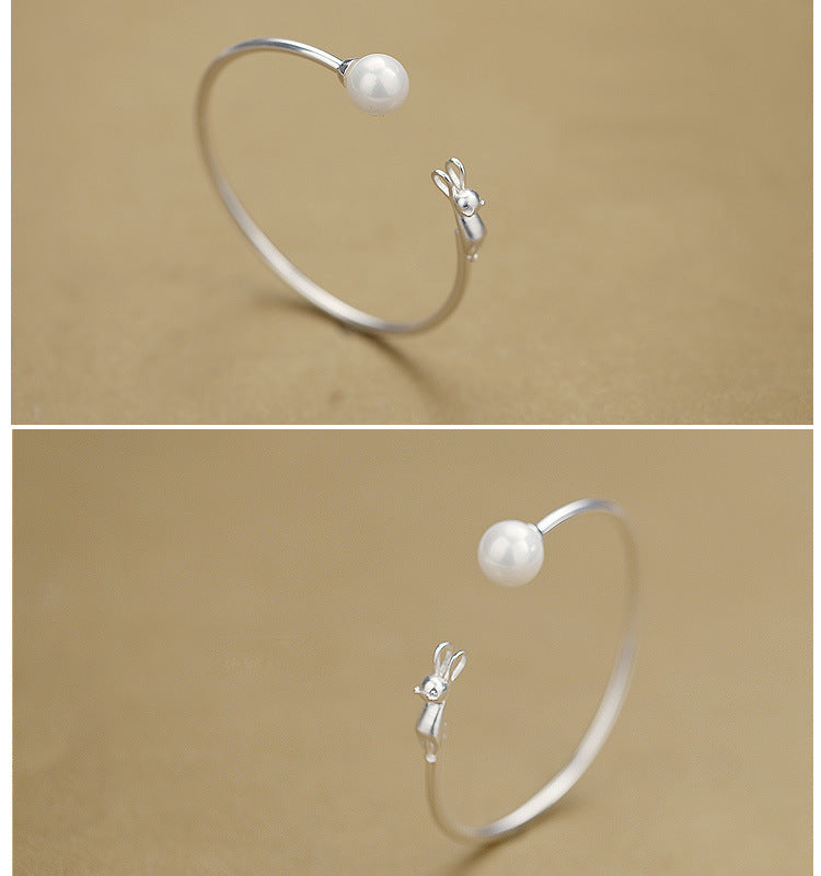 Slim silver bangle bracelet with round pearl bead and small cat charm