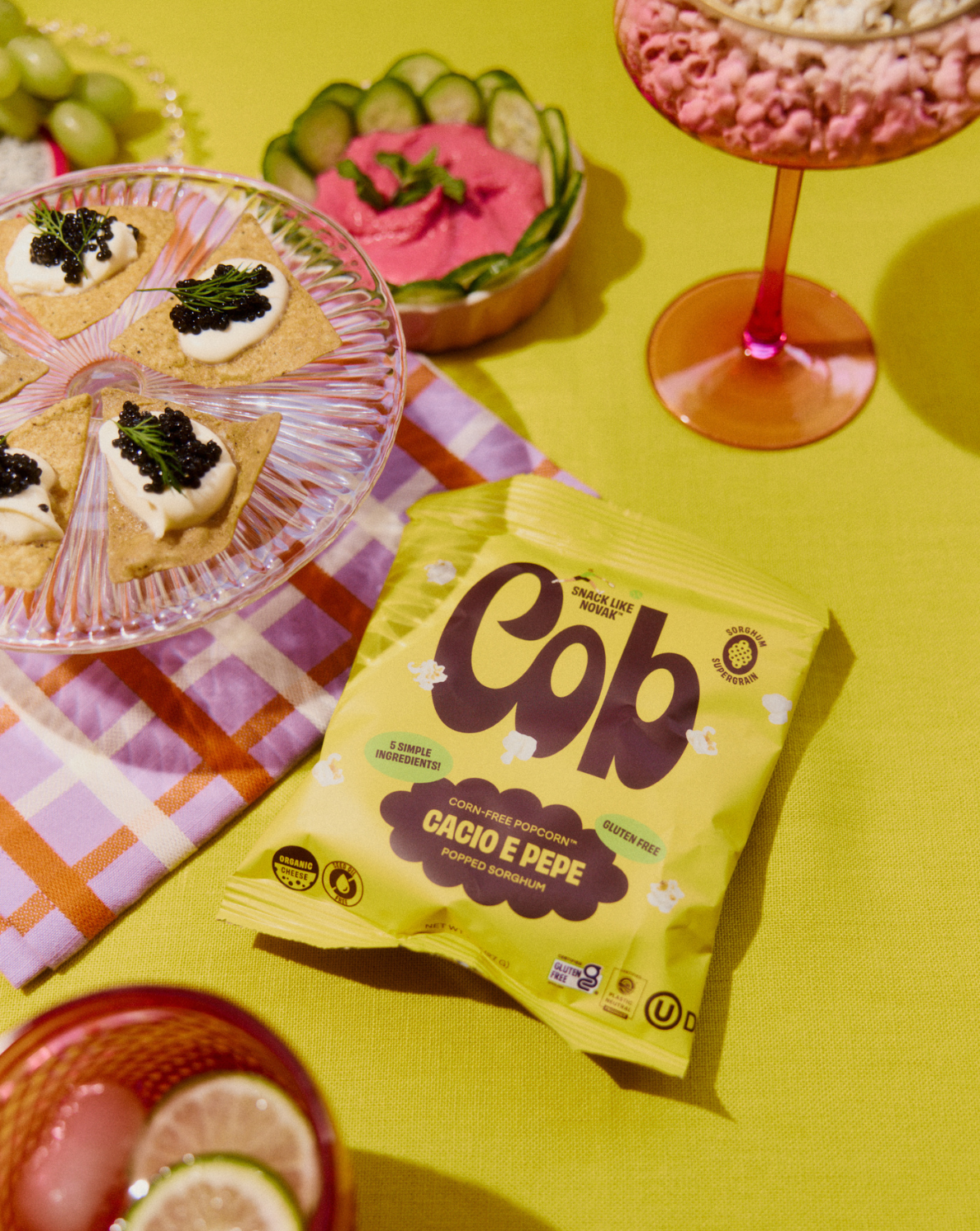 Green Gob popcorn snack bag on a table with small desserts