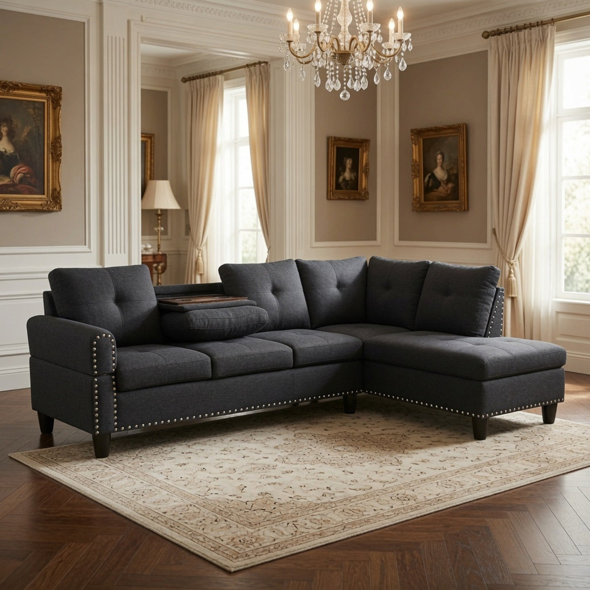 L-shaped sectional sofa in dark gray fabric with nailhead trim along the arms and base