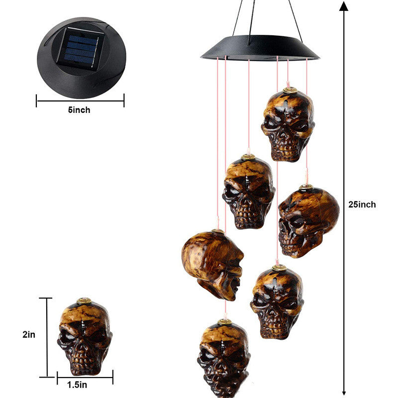 Skull solar LED wind chime with black top and six hanging skull ornaments, 25in