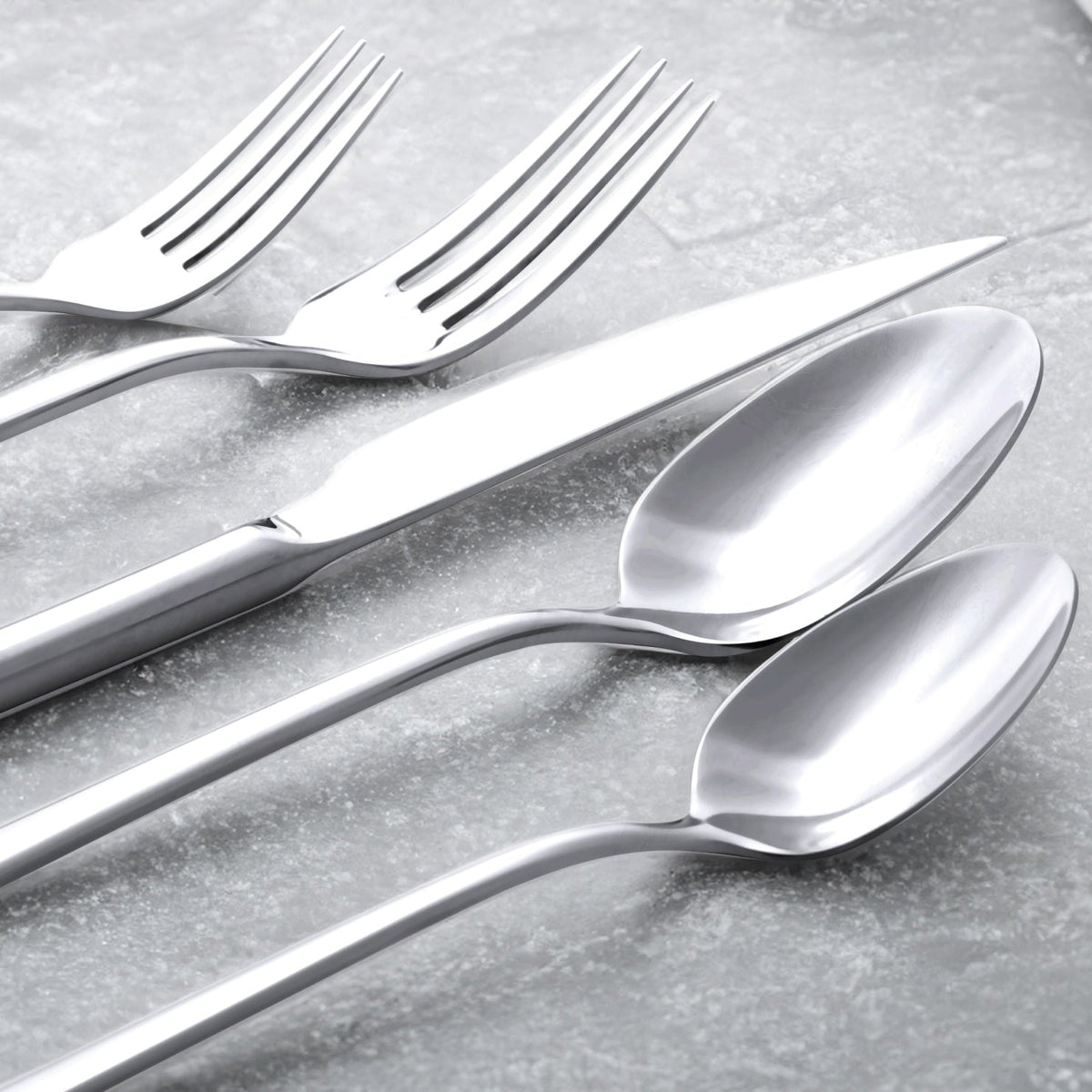 Close-up of silver mirror-finish flatware spoons and fork tines