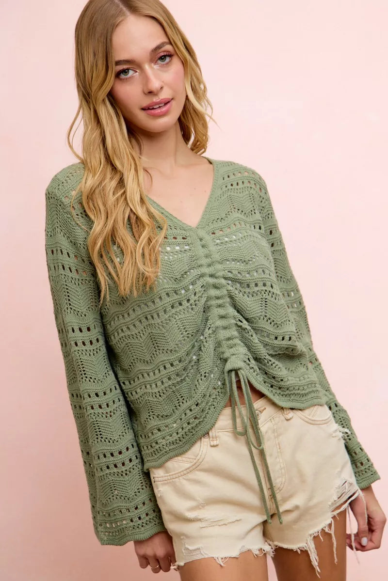 Lightweight sage green pointelle knit V-neck top with ruched front and long sleeves