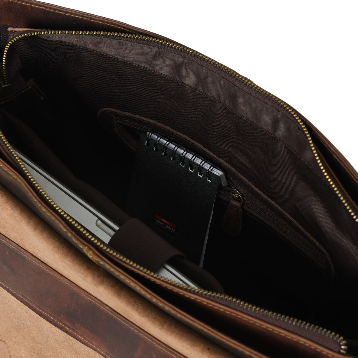 Interior of brown leather briefcase showing zipper lining and open compartments.
