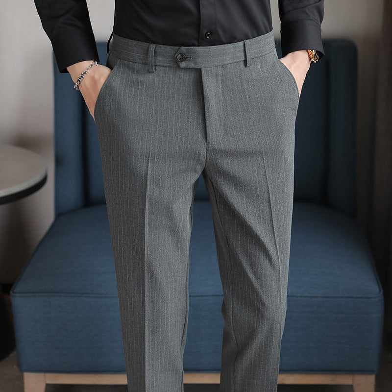 Men's slim-fit gray trousers with front crease, belt loops, and button waist closure
