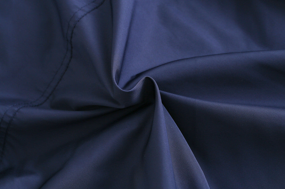 Navy kids jacket fabric close-up with smooth, crinkled outer texture