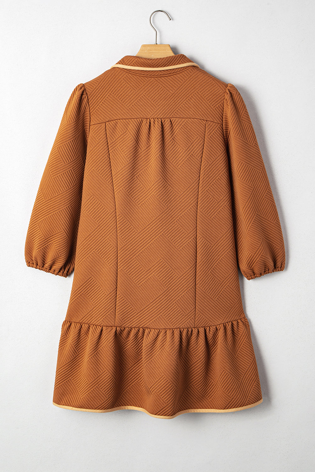 Back view of desert gold textured mini dress with quarter-zip yoke and ruffle hem