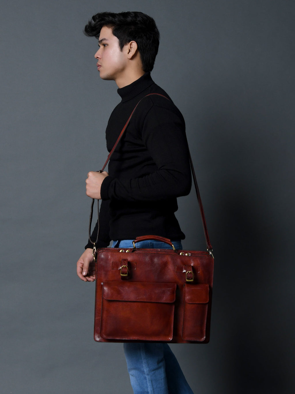 Tan leather briefcase with shoulder strap, front flap, and buckle hardware.