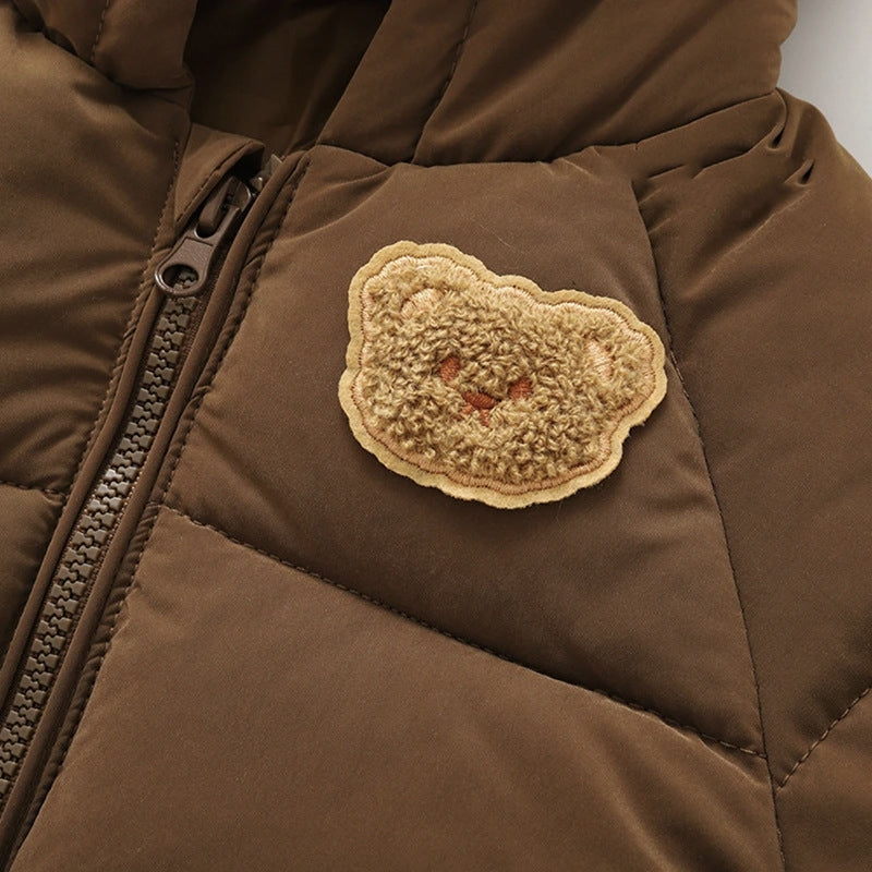 Close-up of dark brown quilted jacket with teddy bear heart patch and zipper