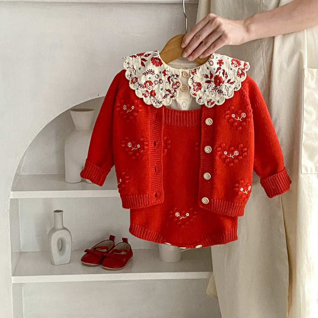 Red knit baby girl cardigan romper with cream scalloped collar and embroidered heart motifs