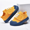 Yellow baby first-walker sneakers with blue textured sole and white lace details