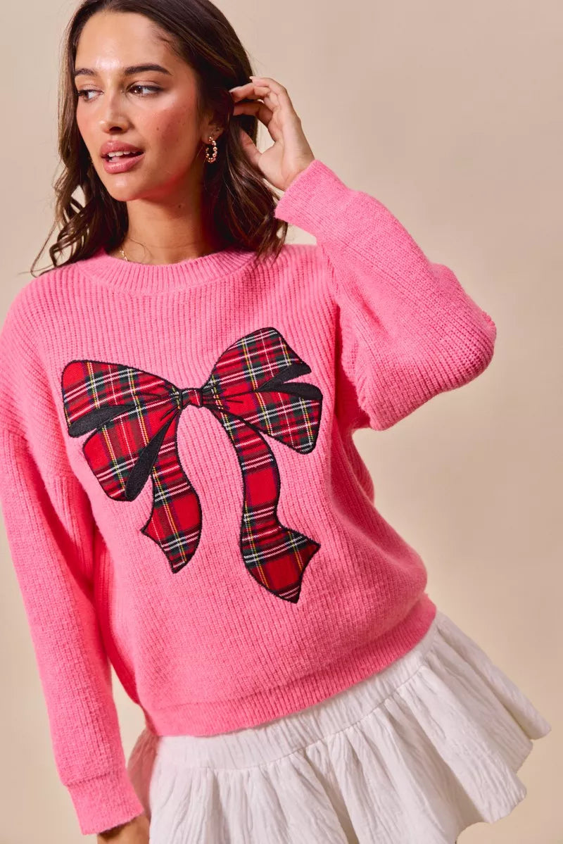 Pink knit sweater featuring a plaid ribbon bow on the chest