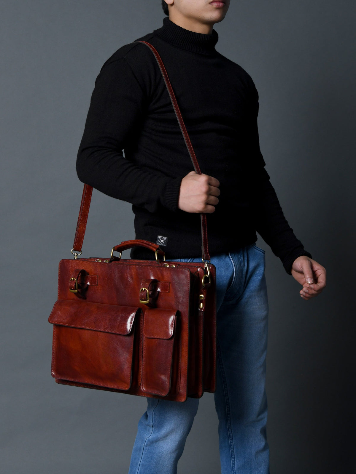 Tan leather briefcase with shoulder strap, front flap, and two organizer pockets.