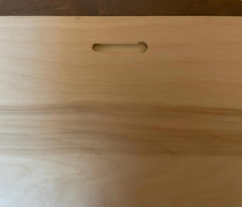 Back of framed wood sign with hanging slot cutout