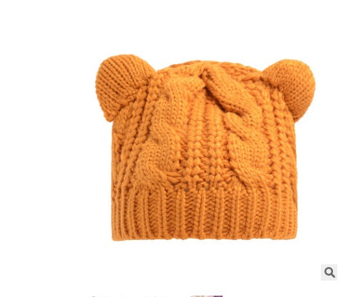 Orange knit beanie with chunky cable pattern and bear-ear design