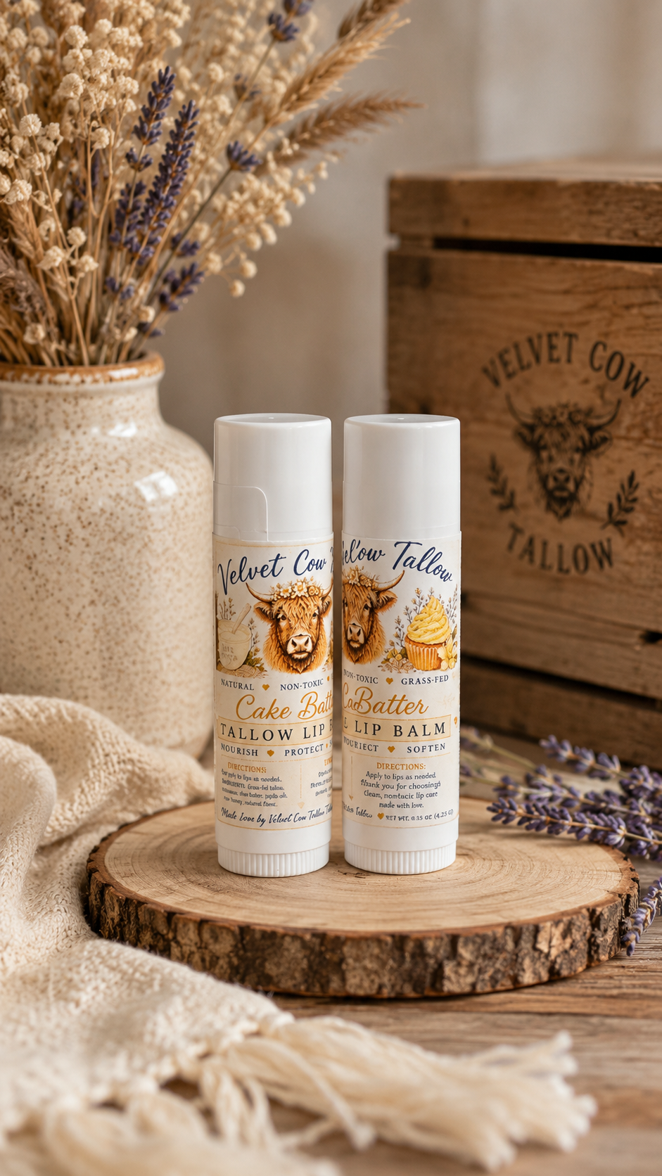 Two lip balm stick tubes displayed on a round wooden slab with lavender