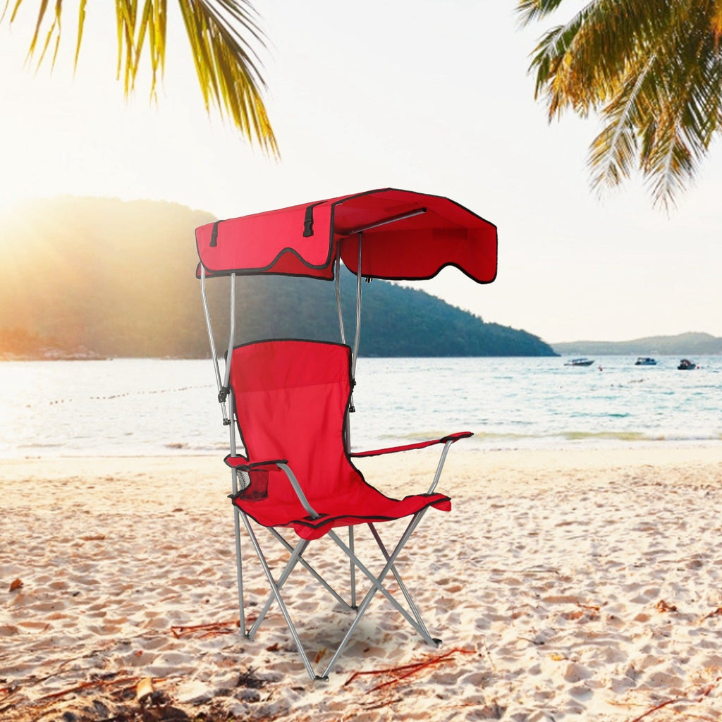 Foldable beach canopy chair in red with sunshade and padded seat on sandy beach
