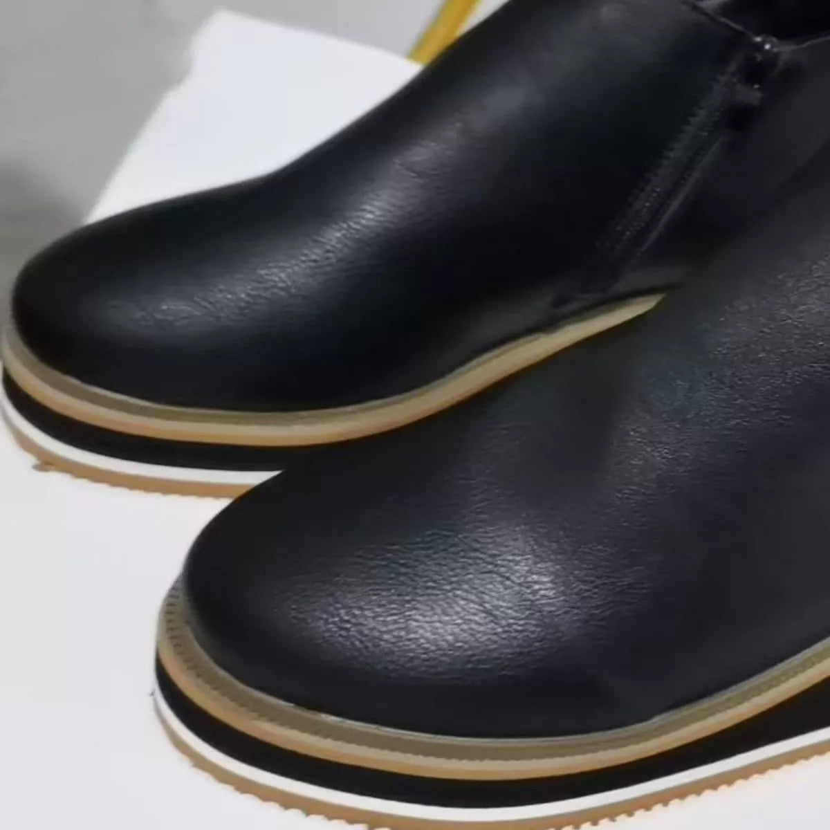 Black ankle wedge boots with side zipper, smooth leather upper, striped outsole