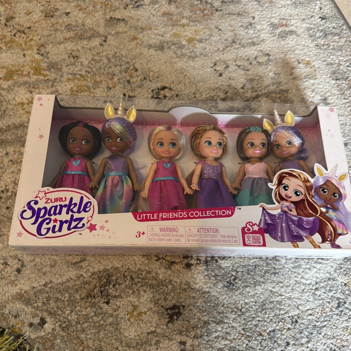 Set of 6 collectible girl dolls in colorful dresses, shown in retail box