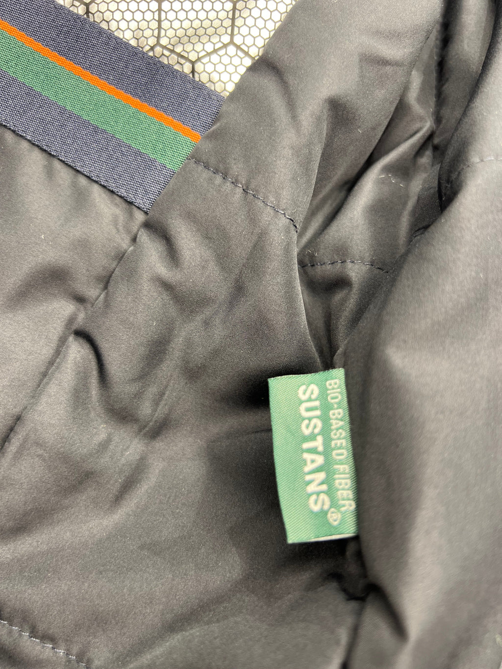 Grey coat sleeve with multicolor stripe label and green interior tag