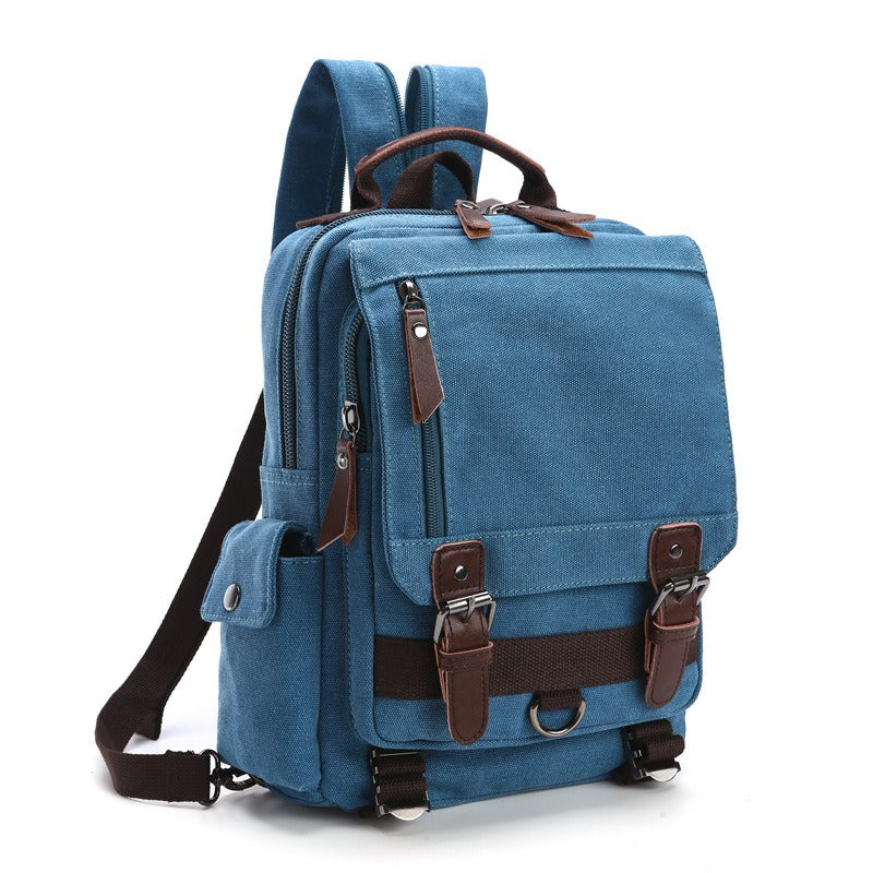 Blue canvas backpack with top handle, front buckled strap, and adjustable shoulder strap