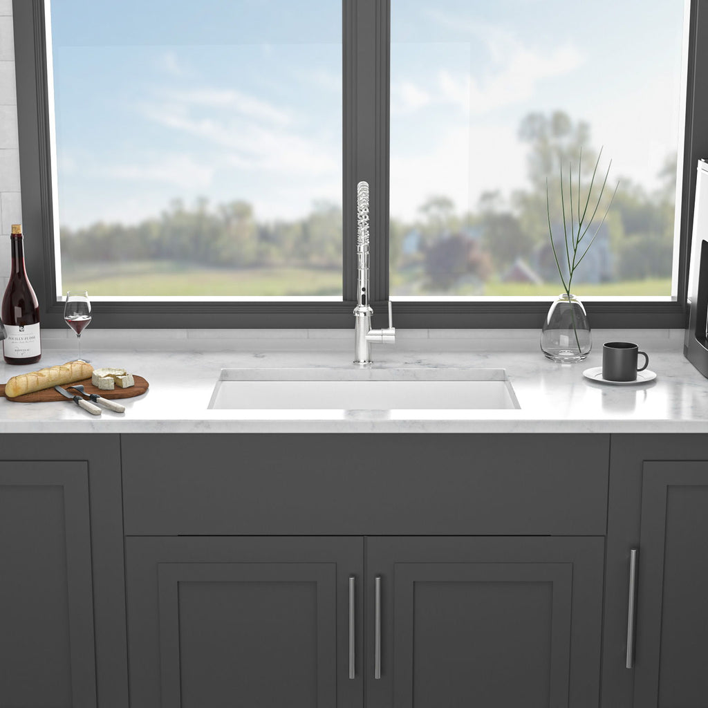 White ceramic single-bowl apron front sink with clean-lined basin and central faucet