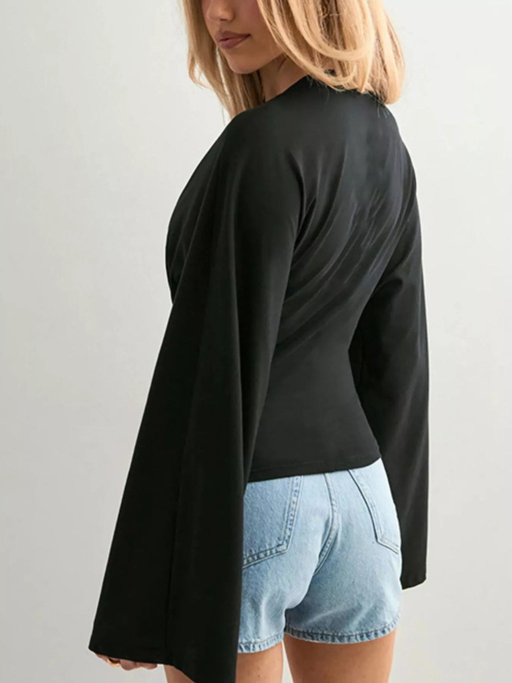 Black long-sleeve fitted t-shirt, side view, crew neck and flared bell sleeves
