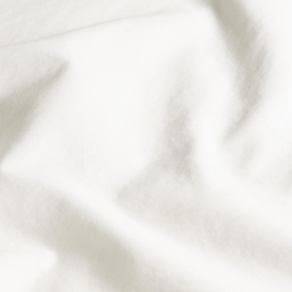 White sateen fabric close-up with soft drape and subtle sheen