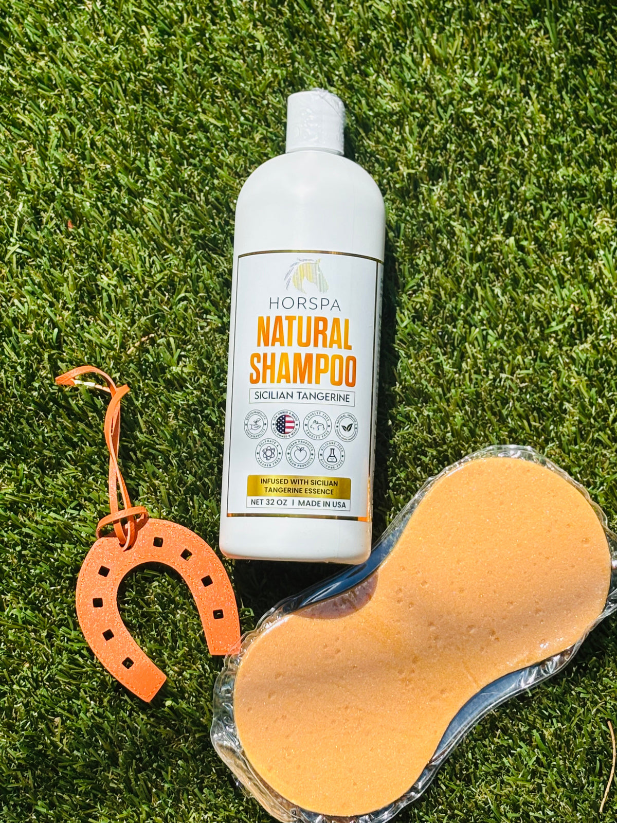 Horspa Natural Shampoo bottle with orange sponge accessory on grass