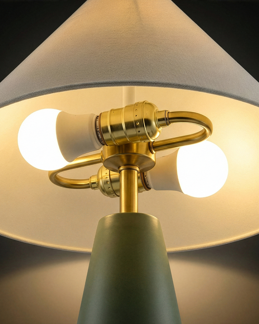 Brass table lamp interior under white shade with multiple exposed globe bulbs