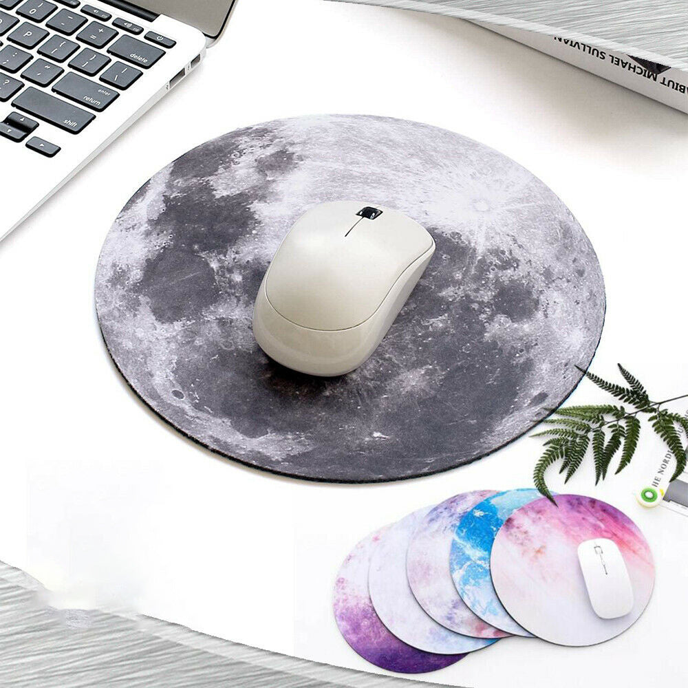 Round galaxy-themed mouse pad in dark gray with white mouse centered on top