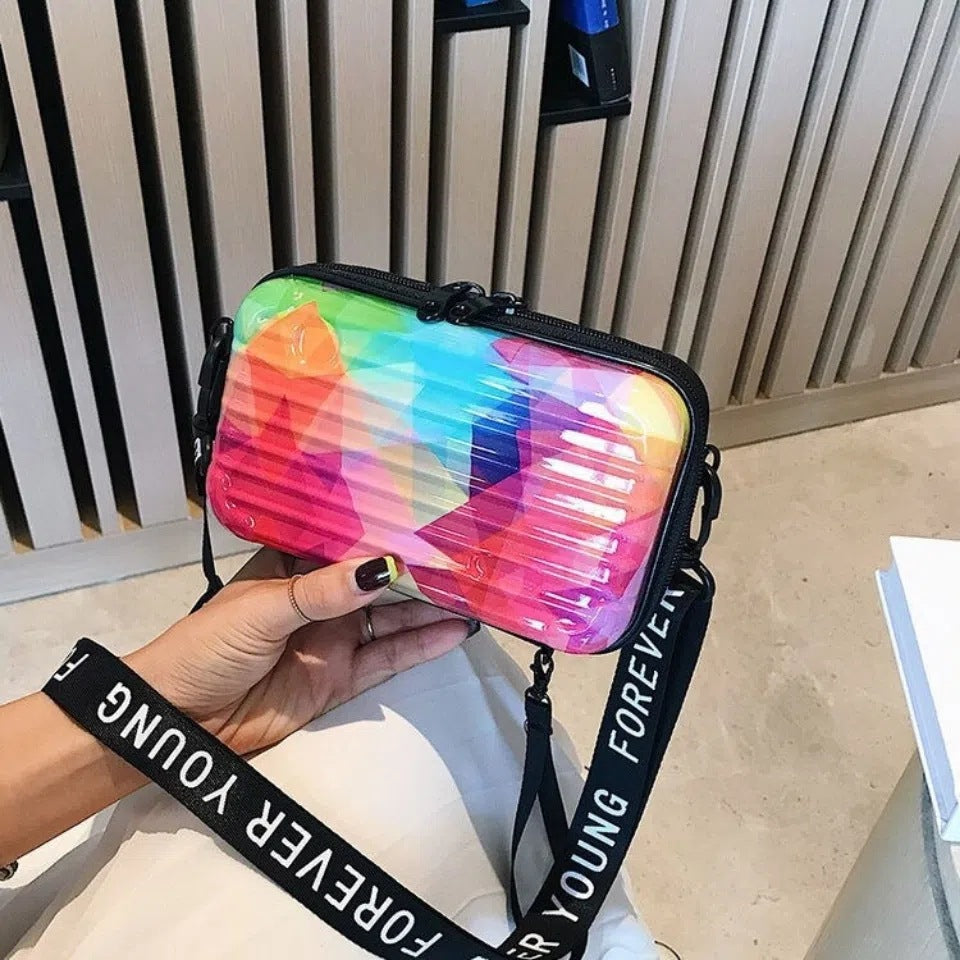 Cosmetic bag with rainbow hologram print, black trim, zip top, crossbody strap