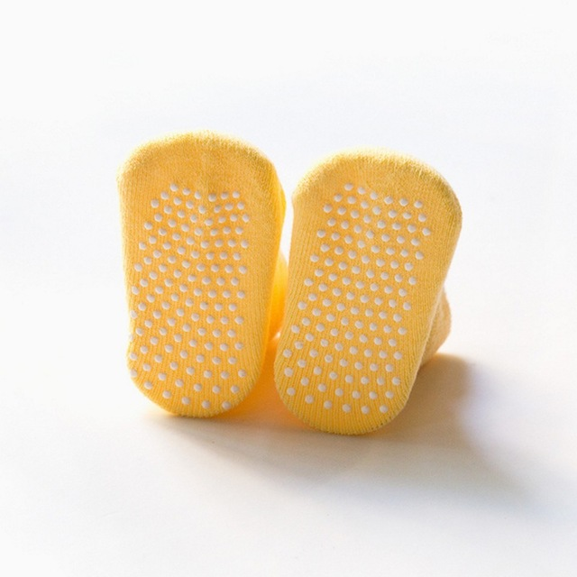Pair of yellow children non-slip socks with full dotted grip on the soles