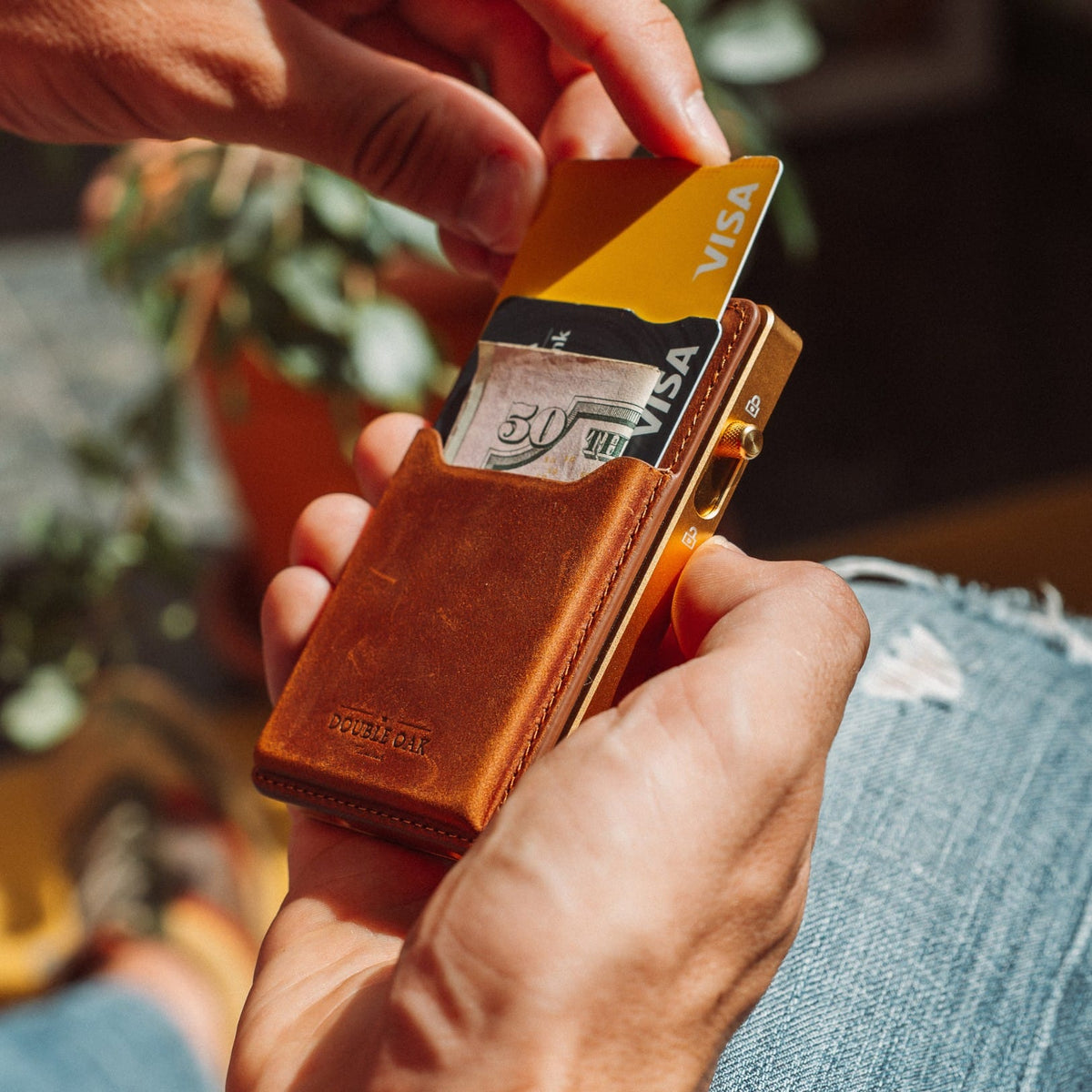 Brown leather card wallet with exposed card tabs and Visa card, compact metal frame