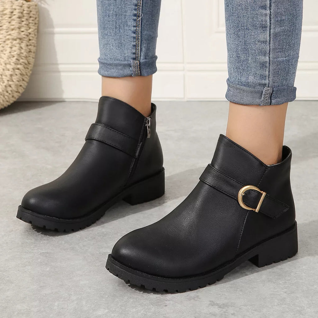 Black ankle boots with buckle accent, chunky sole, side zipper.