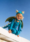 Turquoise dragon costume with gold-trim wings and headpiece, toddler in jumpsuit and cape.