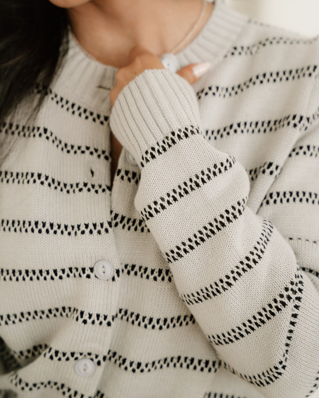 Close-up of button-front ribbed trim cardigan with dark striped knit and round buttons