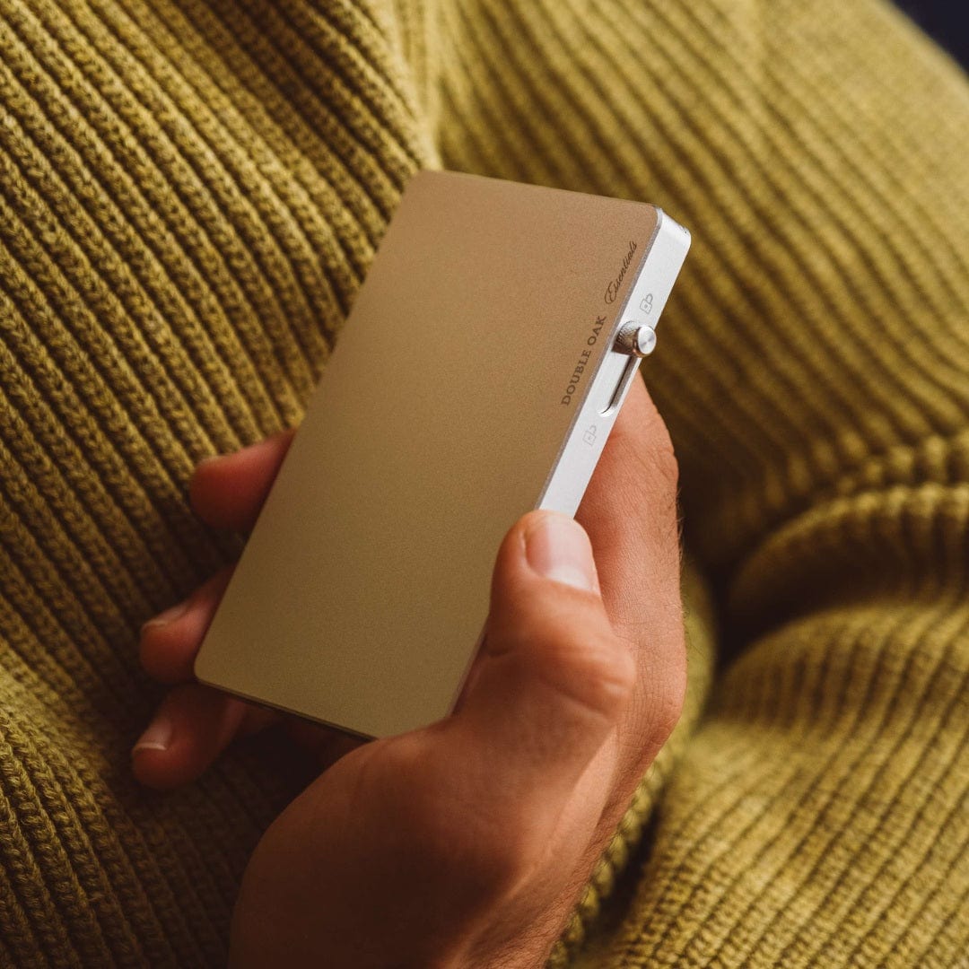 Beige pop-up cardholder with metal pop-release, held between fingers
