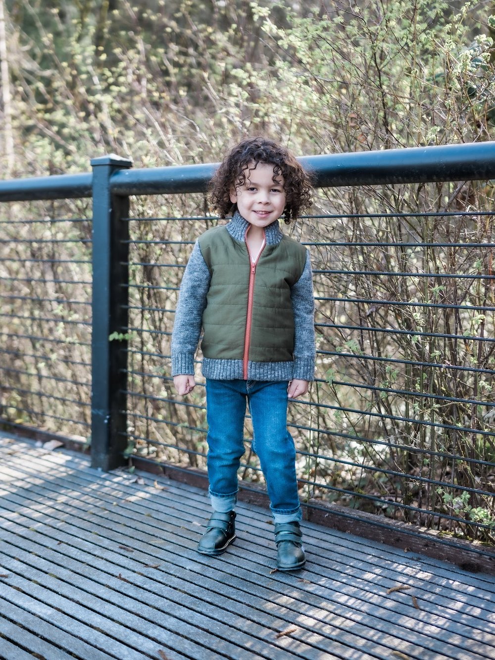 Kids dark slip-on barefoot shoes on child standing on wooden deck