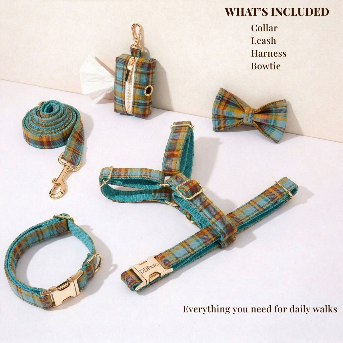 Plaid dog collar, leash, harness, and bowtie laid out with gold clasps