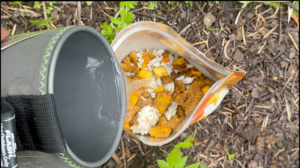 Italian sausage risotto pouch open with bowl and spoon on ground