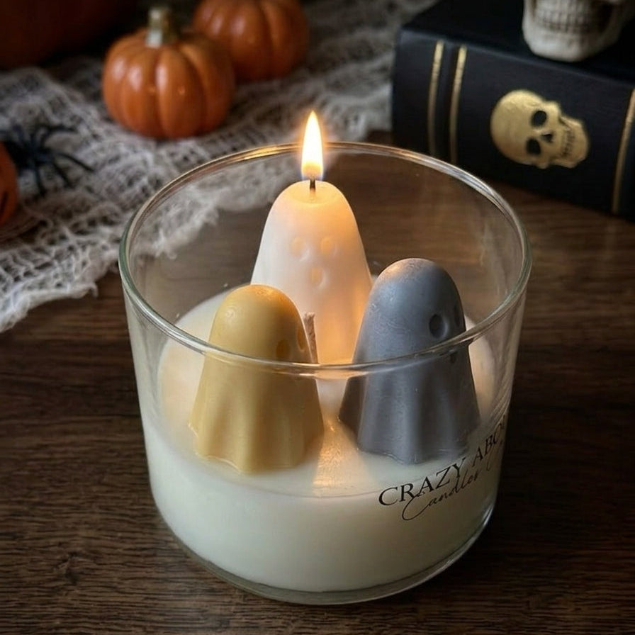 Halloween ghost trio soy candle in glass tumbler with three lit ghost candles, pale yellow and gray